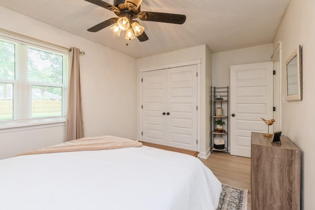 1148 Pin Oak Cir, Niceville, FL 32578 - bedroom with light wood-style floors, a closet, a ceiling fan, and a textured ceiling