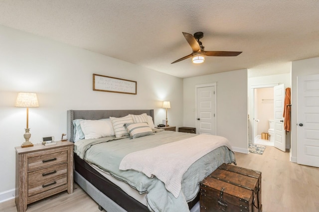 1148 Pin Oak Cir, Niceville, FL 32578 - bedroom featuring light wood-style floors, baseboards, a textured ceiling, ceiling fan, and ensuite bathroom