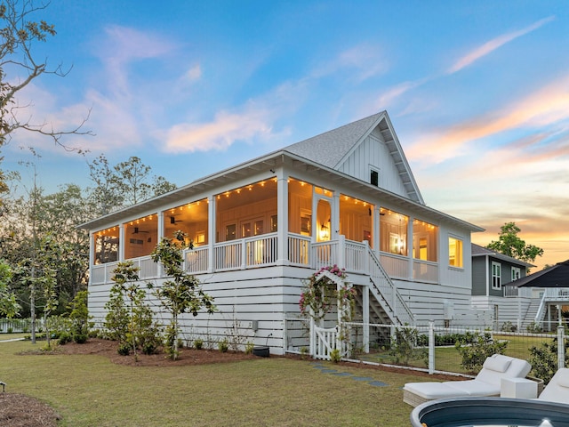 241 N 7th St, Santa Rosa Beach, FL 32459 - view of front facade with stairway, ceiling fan, board and batten siding, a front yard, and covered porch