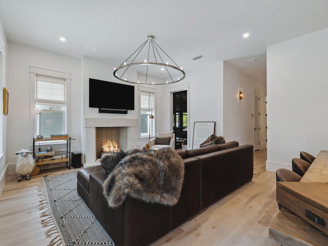 241 N 7th St, Santa Rosa Beach, FL 32459 - living room with light wood-style flooring, recessed lighting, healthy amount of natural light, a chandelier, and a warm lit fireplace
