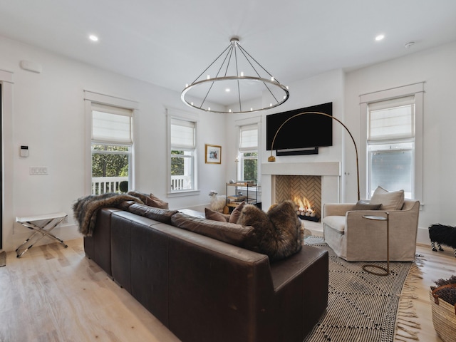 241 N 7th St, Santa Rosa Beach, FL 32459 - living room with recessed lighting, light wood finished floors, a warm lit fireplace, a chandelier, and baseboards