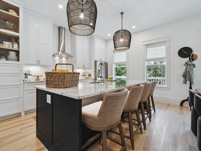 241 N 7th St, Santa Rosa Beach, FL 32459 - kitchen featuring wall chimney exhaust hood, a kitchen island with sink, light wood-style floors, white cabinetry, and recessed lighting