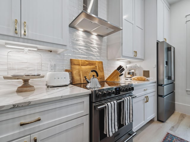 241 N 7th St, Santa Rosa Beach, FL 32459 - kitchen featuring wall chimney range hood, electric range oven, light wood-type flooring, white cabinets, and decorative backsplash