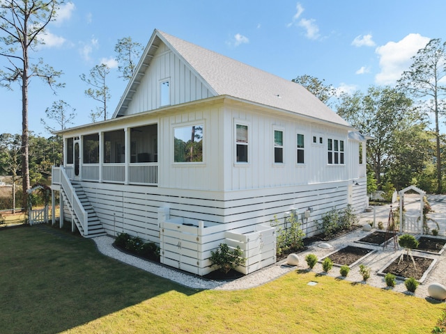 241 N 7th St, Santa Rosa Beach, FL 32459 - view of property exterior with board and batten siding, a garden, a yard, and a sunroom
