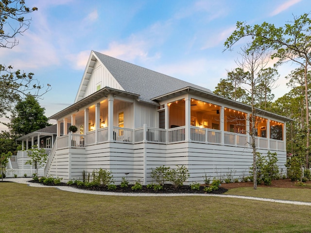 241 N 7th St, Santa Rosa Beach, FL 32459 - view of home's exterior with a lawn, a shingled roof, stairs, and board and batten siding