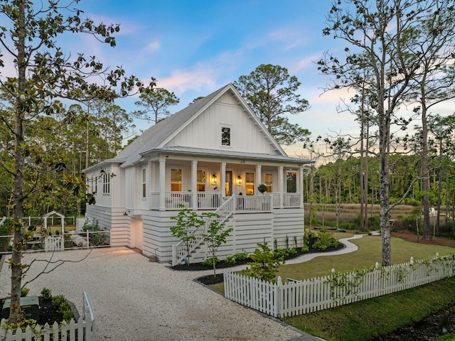 241 N 7th St, Santa Rosa Beach, FL 32459 - view of front of house featuring a porch, stairway, board and batten siding, and a fenced front yard