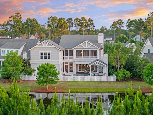 55 Seastone Ct, Watersound, FL 32461 - back of property at dusk featuring a chimney, a sunroom, and a patio area