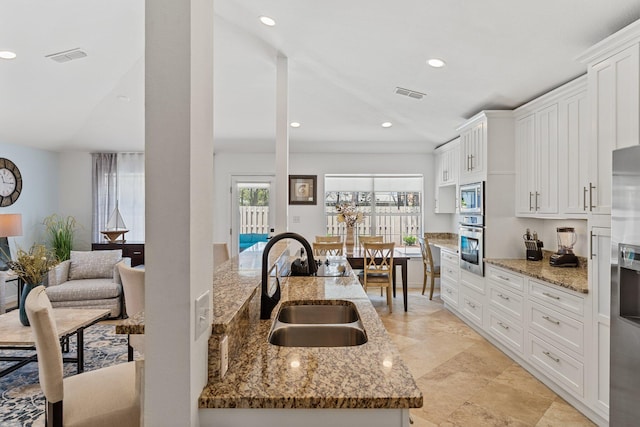 276 Sandy Cay Dr, Miramar Beach, FL 32550 - kitchen with a sink, white cabinets, light stone counters, stainless steel appliances, and recessed lighting