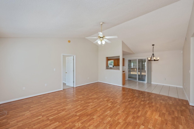 390 Brackin St, Crestview, FL 32539 - unfurnished living room with a chandelier, light wood-style floors, a ceiling fan, baseboards, and high vaulted ceiling