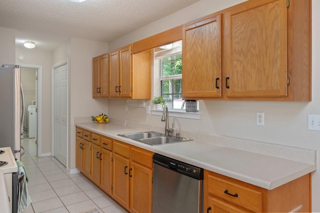 390 Brackin St, Crestview, FL 32539 - kitchen with appliances with stainless steel finishes, a sink, light tile patterned flooring, washer / dryer, and light countertops