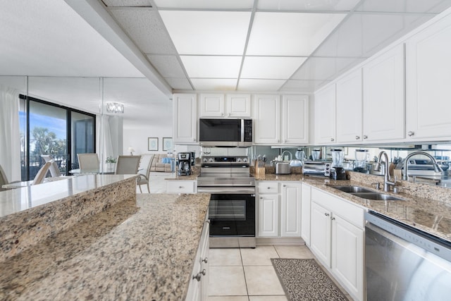 11483 Front Beach Rd Unit 202, Panama City Beach, FL 32407 - kitchen featuring stainless steel appliances, a sink, light tile patterned flooring, and white cabinets
