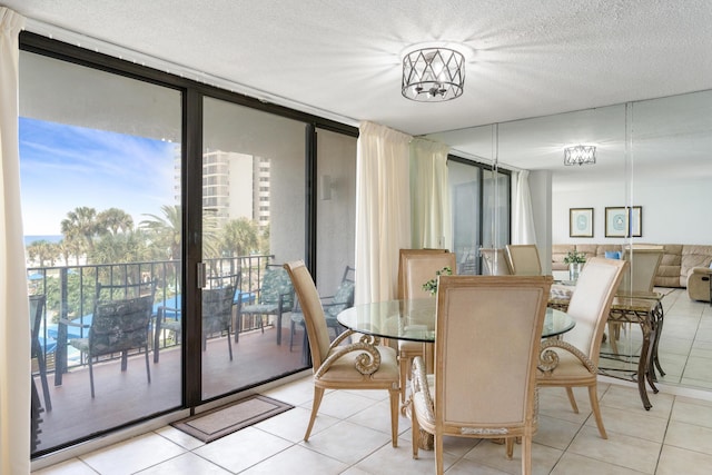 11483 Front Beach Rd Unit 202, Panama City Beach, FL 32407 - dining room with light tile patterned floors, a wall of windows, and a textured ceiling