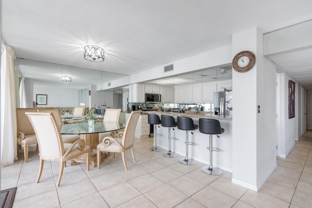 11483 Front Beach Rd Unit 202, Panama City Beach, FL 32407 - dining space featuring light tile patterned flooring and a textured ceiling