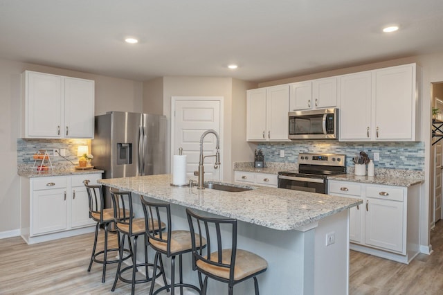 5378 Wyndell Cir, Crestview, FL 32539 - kitchen with stainless steel appliances, a sink, light wood-style floors, white cabinets, and recessed lighting