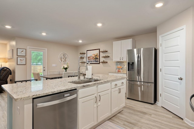 5378 Wyndell Cir, Crestview, FL 32539 - kitchen featuring stainless steel appliances, a sink, white cabinetry, light stone countertops, and an island with sink