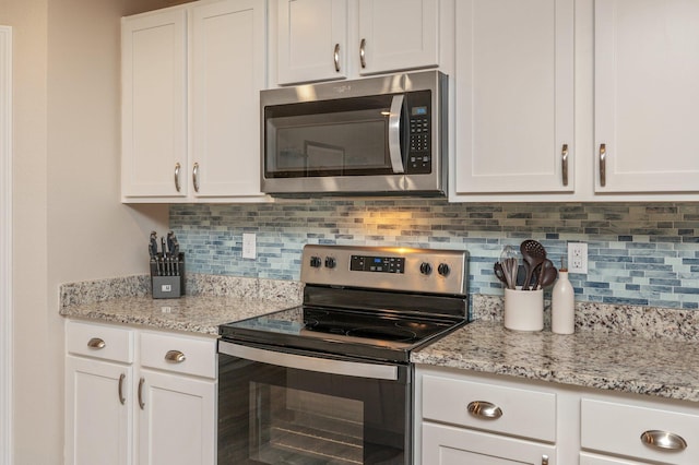 5378 Wyndell Cir, Crestview, FL 32539 - kitchen featuring appliances with stainless steel finishes, white cabinets, tasteful backsplash, and light stone counters