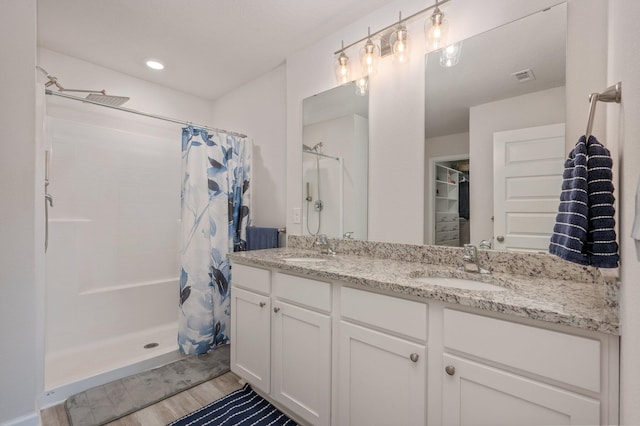 5378 Wyndell Cir, Crestview, FL 32539 - full bath with a shower with shower curtain, wood finished floors, and double vanity