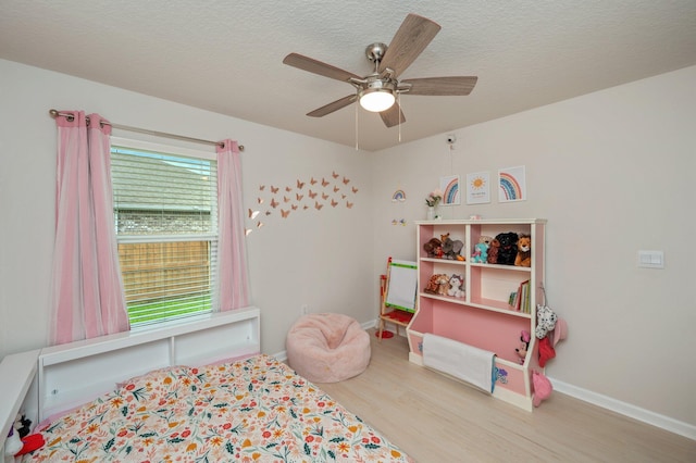 5378 Wyndell Cir, Crestview, FL 32539 - bedroom featuring wood finished floors, baseboards, a ceiling fan, and a textured ceiling
