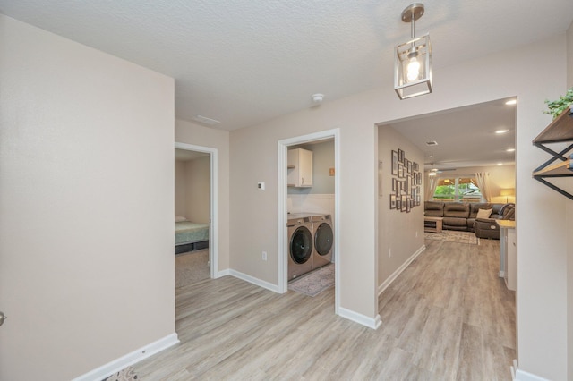 5378 Wyndell Cir, Crestview, FL 32539 - hallway with independent washer and dryer, light wood-style flooring, and baseboards