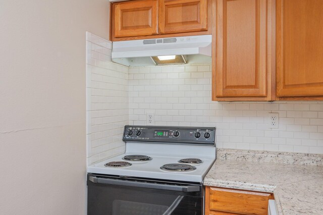 209 W Miracle Strip Pkwy Unit C 202, Mary Esther, FL 32569 - kitchen with range with electric stovetop, under cabinet range hood, decorative backsplash, and brown cabinets