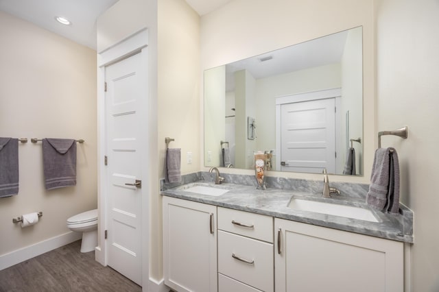 340 Bluefish Dr Unit 106, Fort Walton Beach, FL 32548 - full bathroom featuring double vanity, toilet, wood finished floors, baseboards, and recessed lighting