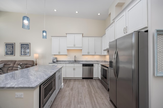 340 Bluefish Dr Unit 106, Fort Walton Beach, FL 32548 - kitchen with stainless steel appliances, a sink, light wood-style flooring, white cabinetry, and light stone countertops