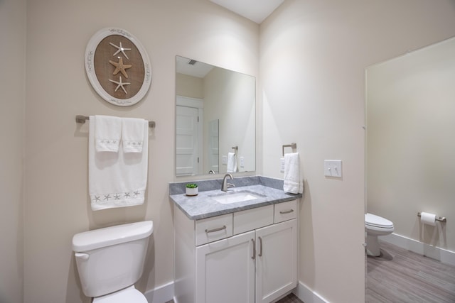 340 Bluefish Dr Unit 106, Fort Walton Beach, FL 32548 - half bath featuring toilet, baseboards, vanity, and wood finished floors