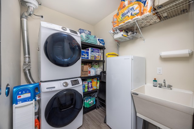 340 Bluefish Dr Unit 106, Fort Walton Beach, FL 32548 - laundry room featuring stacked washer / dryer and wood finished floors