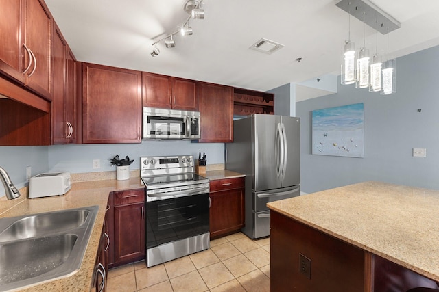 9860 S Thomas Dr Unit 726, Panama City Beach, FL 32408 - kitchen featuring stainless steel appliances, a sink, light tile patterned flooring, pendant lighting, and dark brown cabinets