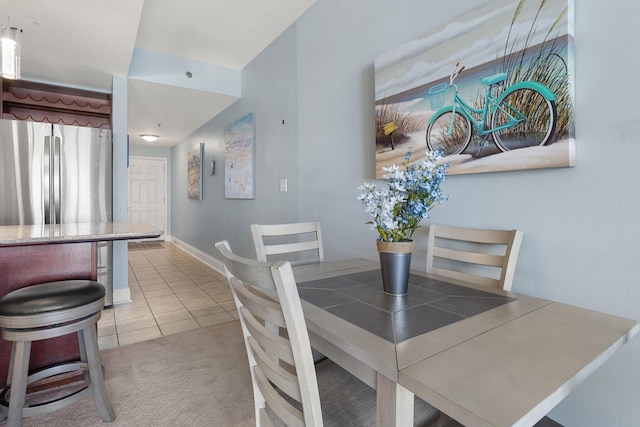 9860 S Thomas Dr Unit 726, Panama City Beach, FL 32408 - dining space featuring light tile patterned flooring, light colored carpet, and baseboards
