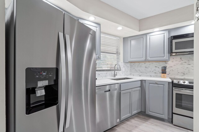 4228 Beachside Two # 228, Miramar Beach, FL 32550 - kitchen with appliances with stainless steel finishes, a sink, gray cabinetry, light countertops, and light wood-style flooring