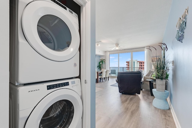 9900 S Thomas Dr Unit 2226, Panama City Beach, FL 32408 - laundry area with stacked washer and clothes dryer, wood finished floors, a ceiling fan, and baseboards