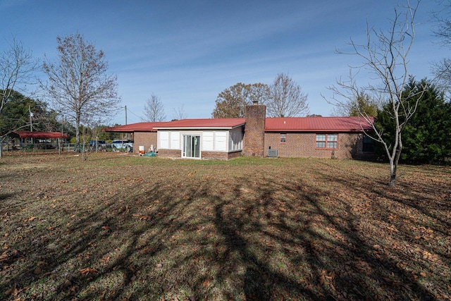 2522 Lake Silver Rd, Crestview, FL 32536 - back of house with a chimney, brick siding, and a yard