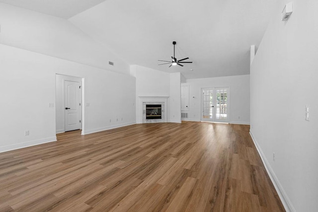 516 Vulpes Sanctuary Loop, Crestview, FL 32536 - unfurnished living room with a ceiling fan, a glass covered fireplace, light wood-type flooring, baseboards, and high vaulted ceiling