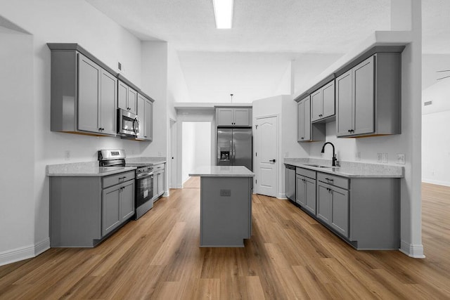 516 Vulpes Sanctuary Loop, Crestview, FL 32536 - kitchen featuring appliances with stainless steel finishes, gray cabinets, a sink, wood finished floors, and a kitchen island