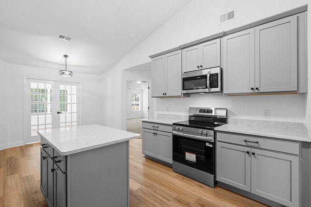 516 Vulpes Sanctuary Loop, Crestview, FL 32536 - kitchen featuring appliances with stainless steel finishes, gray cabinetry, vaulted ceiling, a center island, and healthy amount of natural light