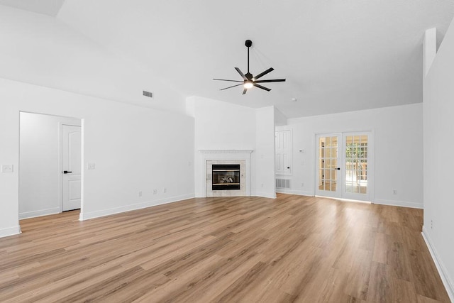 516 Vulpes Sanctuary Loop, Crestview, FL 32536 - unfurnished living room with a ceiling fan, vaulted ceiling, light wood-style flooring, a tiled fireplace, and baseboards