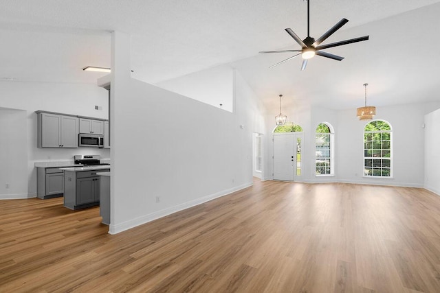 516 Vulpes Sanctuary Loop, Crestview, FL 32536 - unfurnished living room with high vaulted ceiling, light wood-style flooring, a ceiling fan, and baseboards
