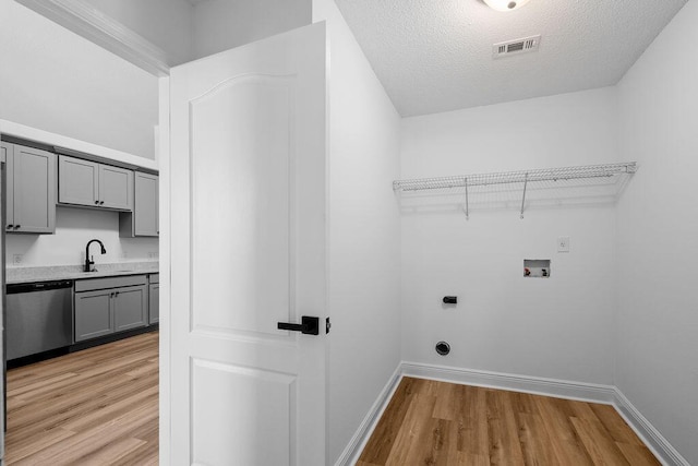 516 Vulpes Sanctuary Loop, Crestview, FL 32536 - washroom with hookup for an electric dryer, washer hookup, light wood-style floors, a sink, and baseboards
