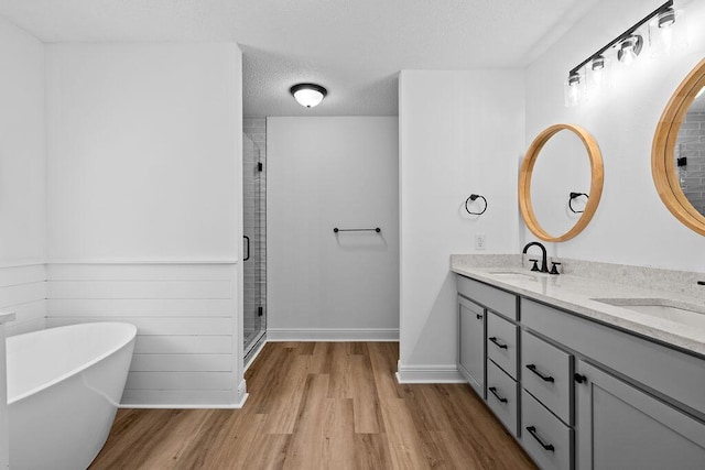 516 Vulpes Sanctuary Loop, Crestview, FL 32536 - full bath with double vanity, a shower stall, wood finished floors, a freestanding tub, and baseboards