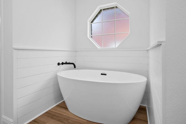 516 Vulpes Sanctuary Loop, Crestview, FL 32536 - bathroom with a freestanding tub, wood finished floors, and wainscoting