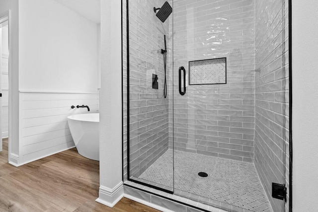 516 Vulpes Sanctuary Loop, Crestview, FL 32536 - full bathroom with a stall shower, wood finished floors, a soaking tub, and baseboards