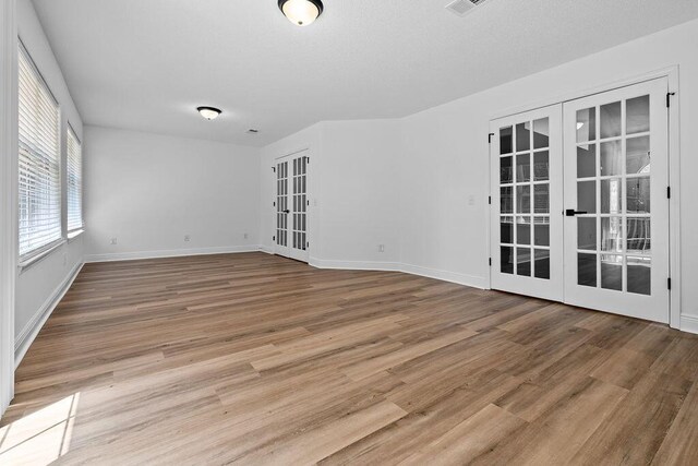 516 Vulpes Sanctuary Loop, Crestview, FL 32536 - empty room with french doors, wood finished floors, and baseboards