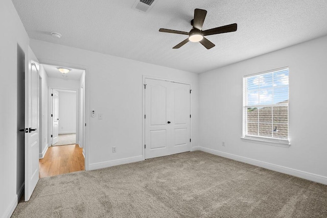 516 Vulpes Sanctuary Loop, Crestview, FL 32536 - unfurnished bedroom featuring carpet, a textured ceiling, baseboards, a closet, and a ceiling fan
