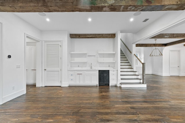80 Shore Bridge Cir, Inlet Beach, FL 32461 - unfurnished living room with bar with sink, dark wood-style floors, stairway, beam ceiling, and recessed lighting
