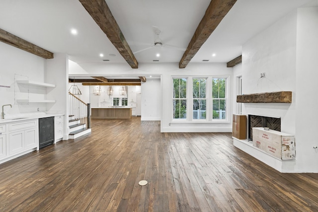 80 Shore Bridge Cir, Inlet Beach, FL 32461 - unfurnished living room featuring dark wood-style flooring, a sink, wine cooler, beam ceiling, and a ceiling fan