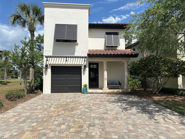 1893 Baytowne Loop, Miramar Beach, FL 32550 - view of front of property featuring a tiled roof, a garage, decorative driveway, stucco siding, and covered porch