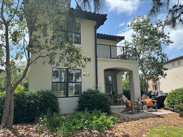 1893 Baytowne Loop, Miramar Beach, FL 32550 - rear view of house featuring a balcony, stucco siding, and a porch