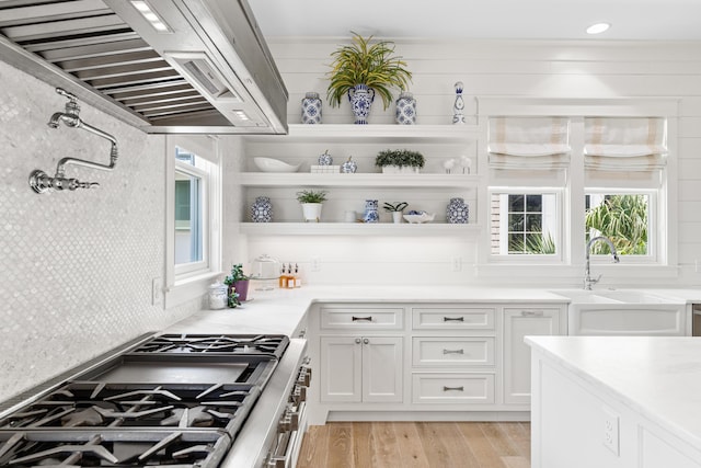 29 Tidal Bridge Way, Watersound, FL 32461 - kitchen with a sink, range hood, stainless steel range with gas stovetop, white cabinets, and light countertops