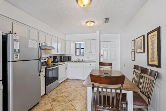 3692 E County Highway 30a Unit 9, Santa Rosa Beach, FL 32459 - kitchen with appliances with stainless steel finishes, a sink, under cabinet range hood, white cabinets, and light tile patterned floors